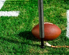 Photo of a football on a field with a pole and chain