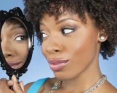 Woman looking in to handheld mirror