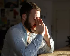 stressed man holding hands to face