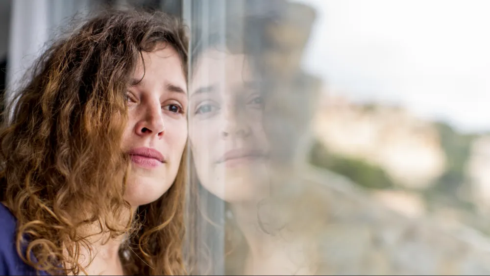 Woman leaning against window 