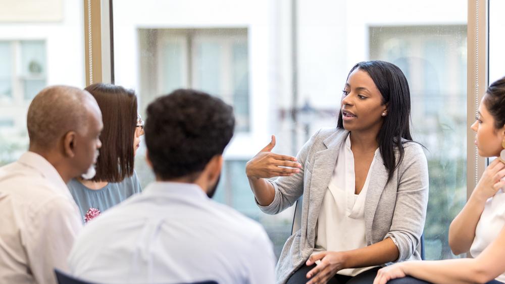 Young business professionals in a circle talking.