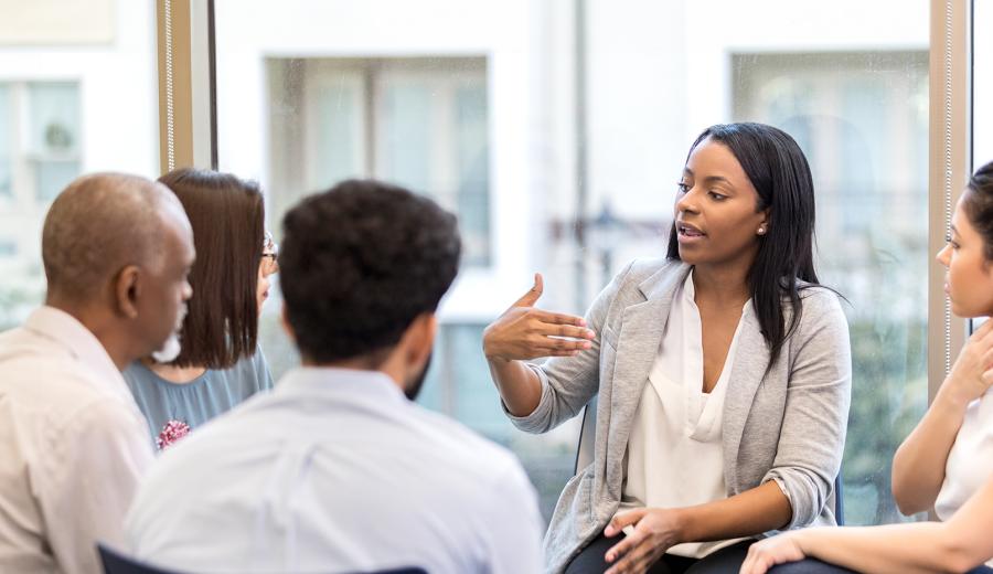 Young business professionals in a circle talking.